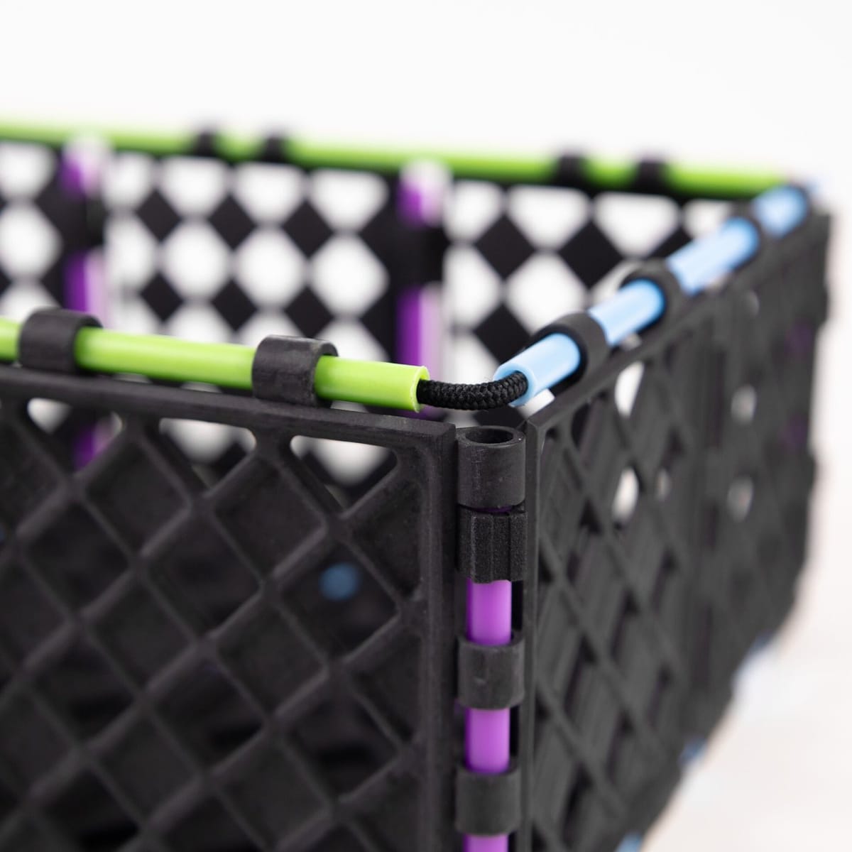Close-up of a black Zerobox corner, with panels joined by coloured rods and an elastic cord